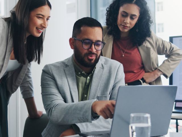 Tre colleghi lavorano ad una presentazione in ufficio