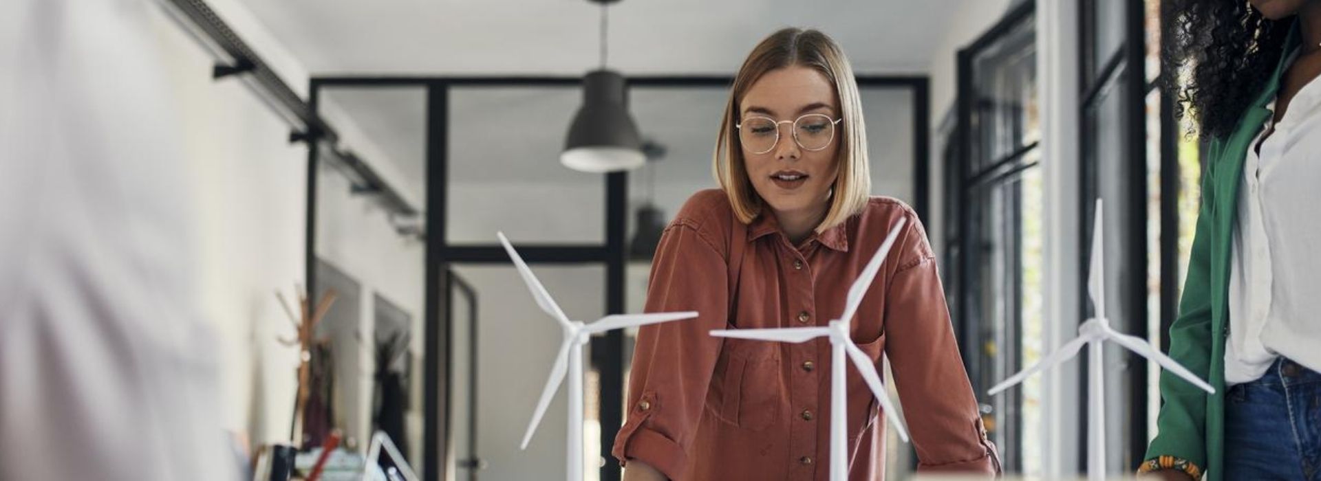 Due esperte dei energie rinnovabili osservano dei modelli di pale eoliche in una sala riunioni