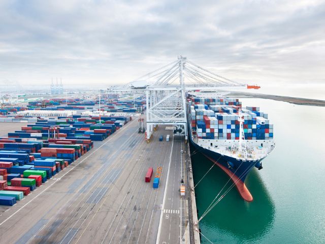 Nave cargo in un porto commerciale in attesa di partire con un carico destinato all'export