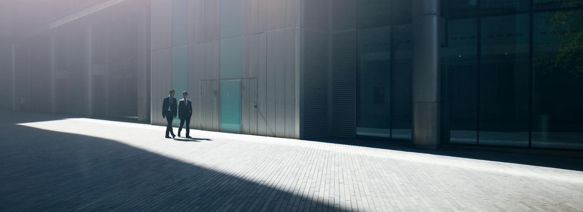 Due colleghi esperti di rischio finanziario si confrontano nel cortile esterno dell'azienda