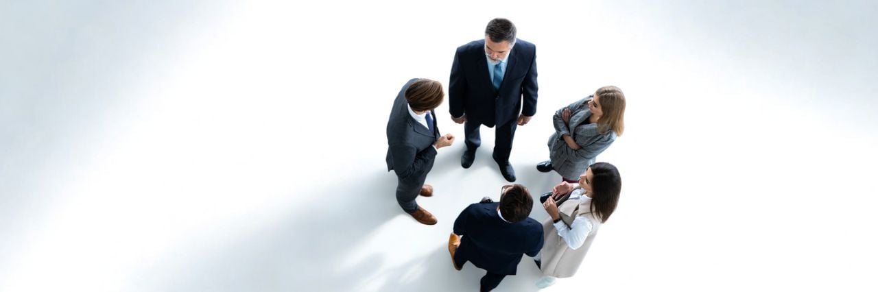 Panoramica di cinque professionisti che collaborano durante un meeting