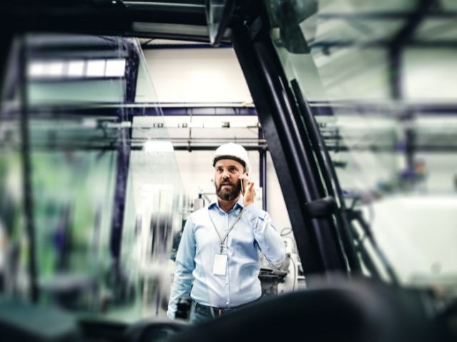 Un tecnico in un magazzino è al telefono con un collega