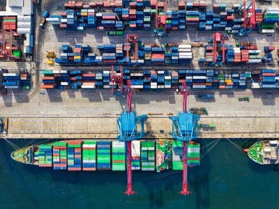 Vista dall'alto del molo di un porto mercantile con container e navi attraccate
