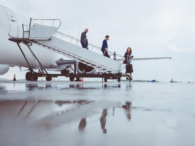 Tre imprenditori scendono dall'aereo per una trasferta di lavoro