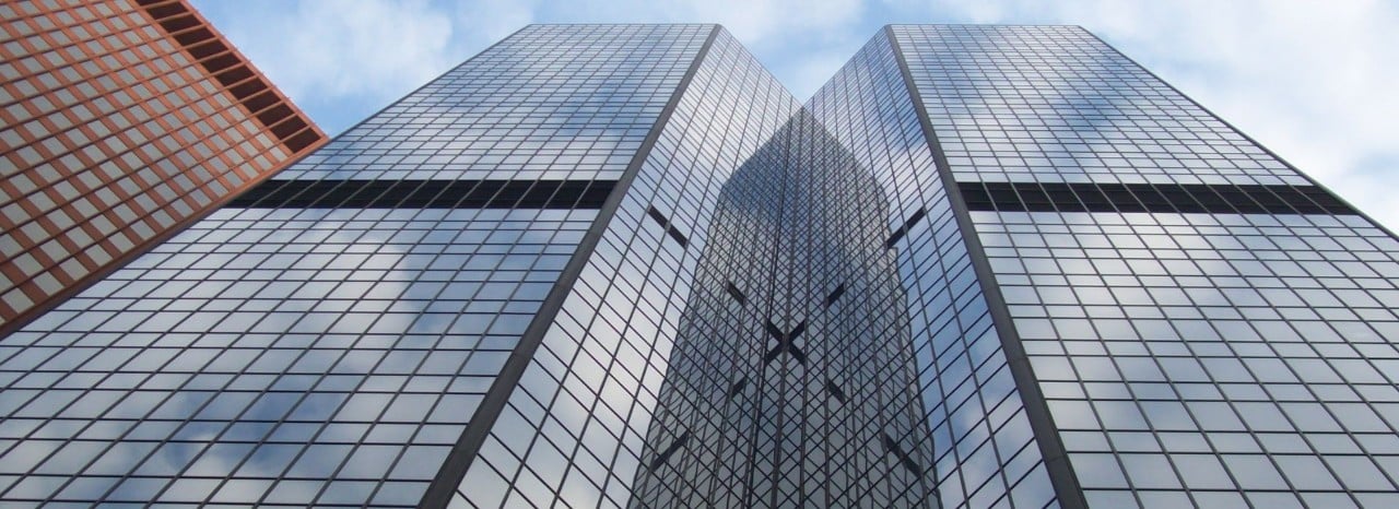 Edifici moderni con facciate in vetro visti dal basso, simbolo di contesto economico internazionale