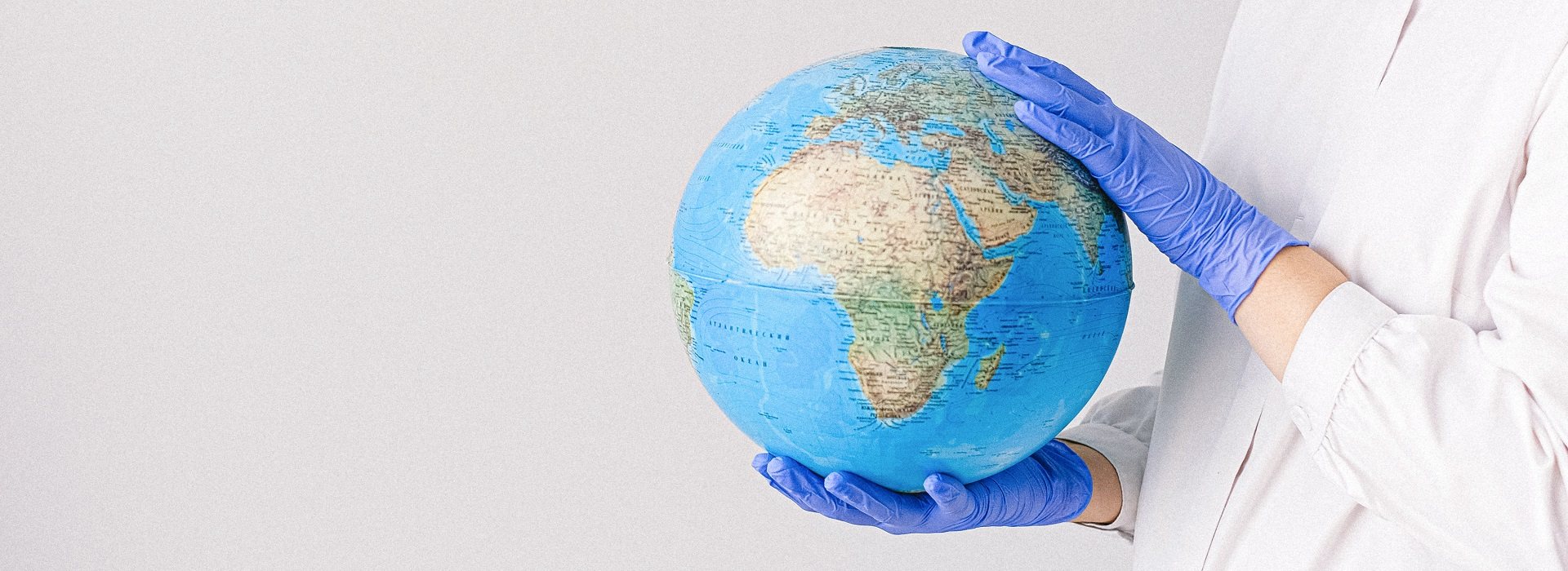 Mappamondo tenuto in mano con dei guanti