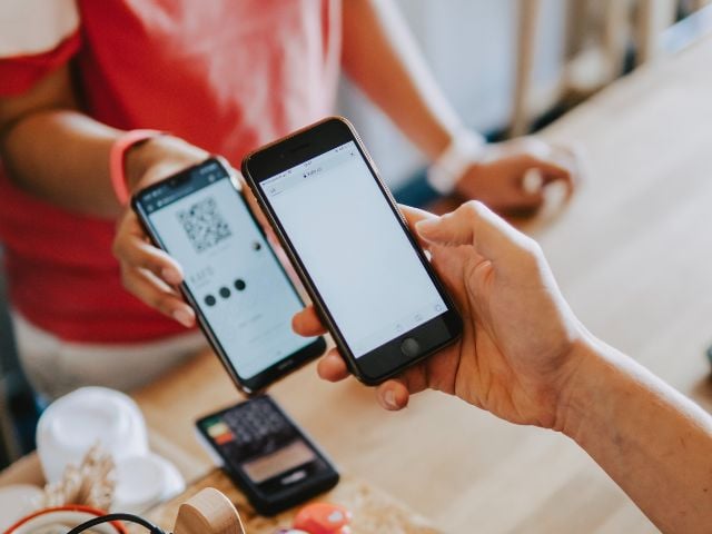 Una cliente effettua un pagamento utlizzando lo smartphone