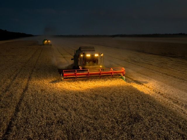 Due trattori arano un campo di notte