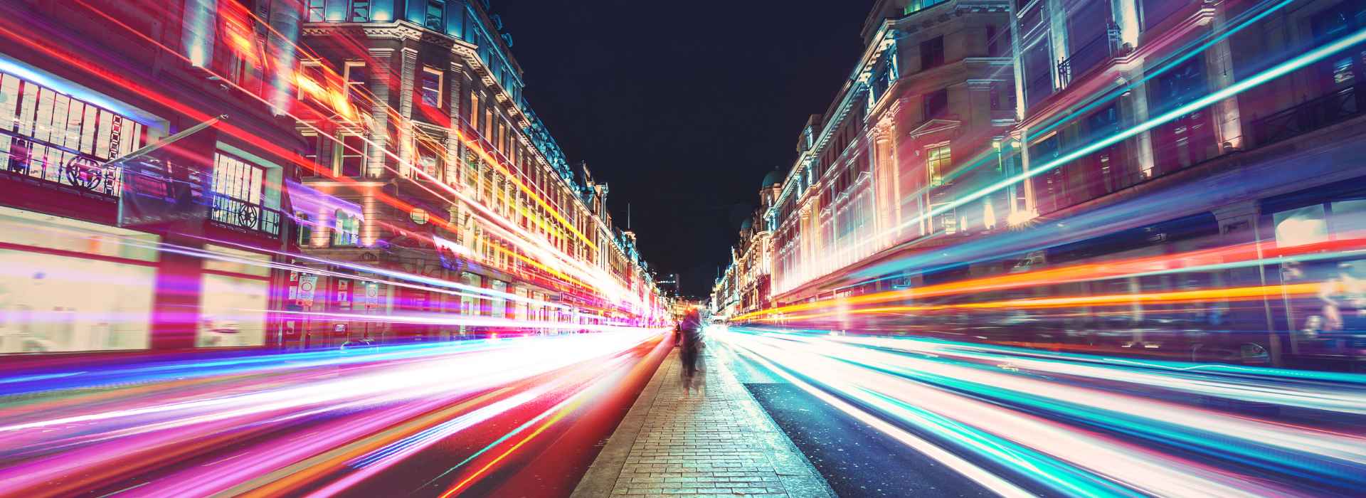 Viale di una città con linee di luci colorate
