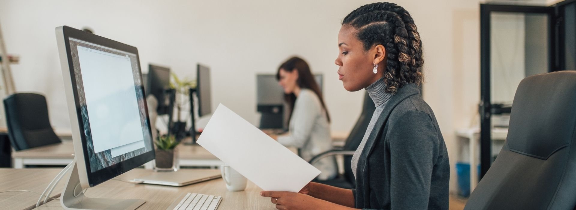Due colleghe lavorano alla propria scrivania in ufficio
