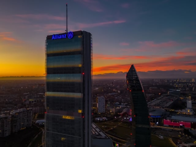 Due tecnici al lavoro in un parco eolico al tramonto