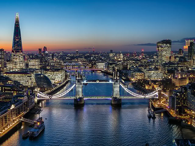 Tower Bridge di Londra all'alba, illuminato e riflesso sulle acque del Tamigi. 