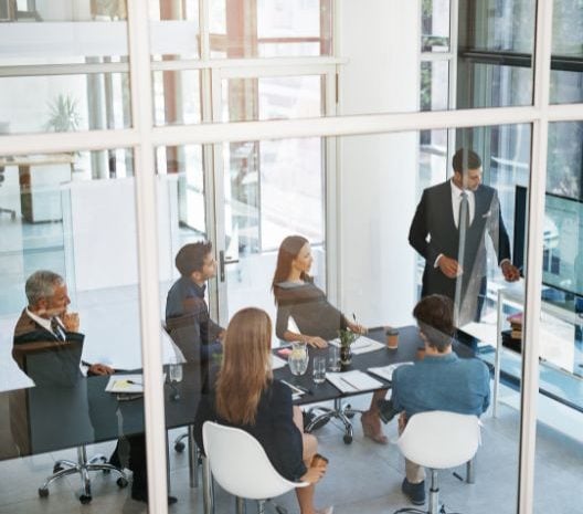 Sei colleghi in una sala riunioni con vetrate