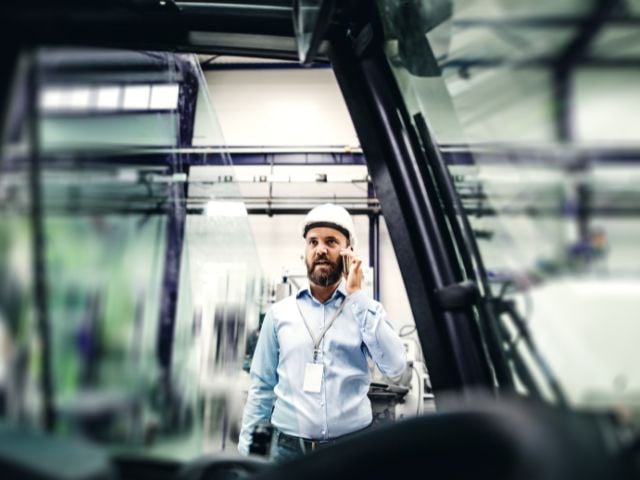 Immagine di un impiegato con elmetto che sta a telefono