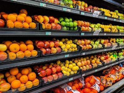 Scaffali di un supermercato su cui sono disposte frutta e verdura fresche