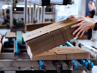 Un lavoratore devo una fabbrica che prepara un pacco da spedire