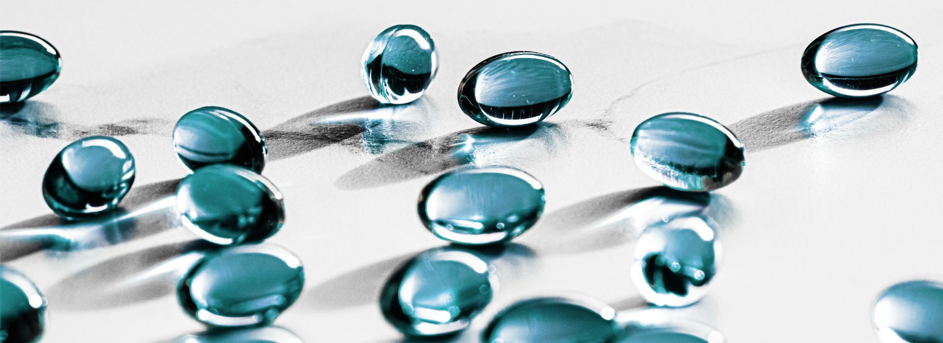 Capsule medicinali di colore celeste, disposte su una superficie piana