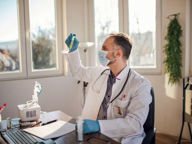 Ricercatore nel suo studio mentre esamina un farmaco contenuto in una provetta