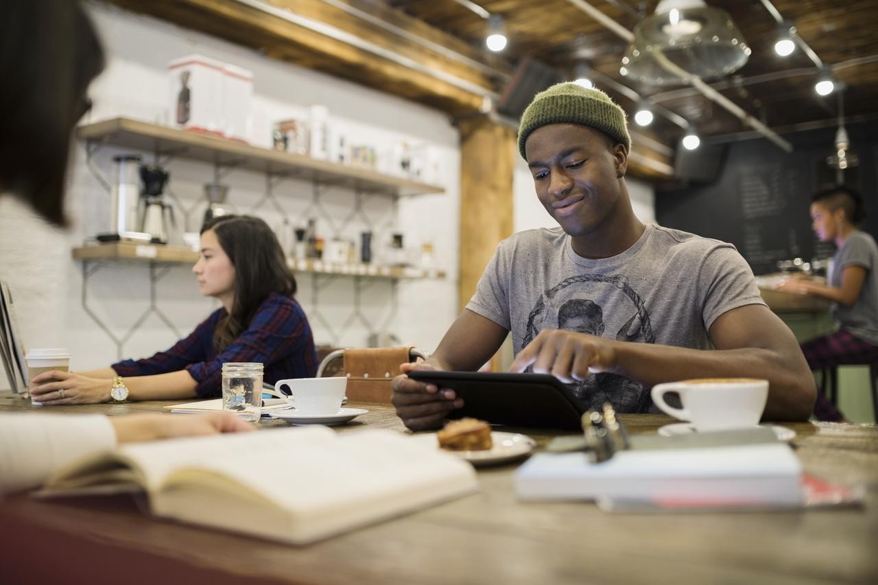 Jonge ondernemer in cafe die zijn cashflow optimaliseert