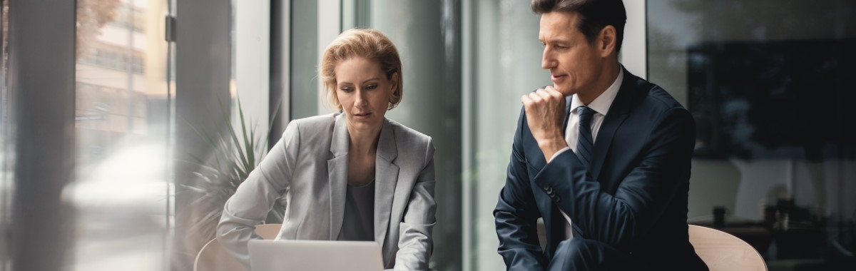 Twee cfo's die overleggen over hun strategie achter een laptop