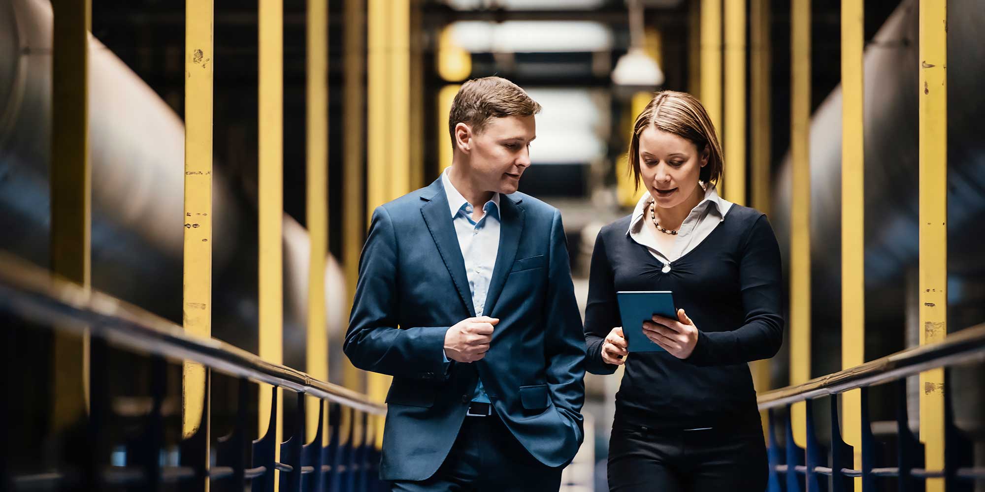 Kobieta z mężczyzną spacerują w hali magazynowej