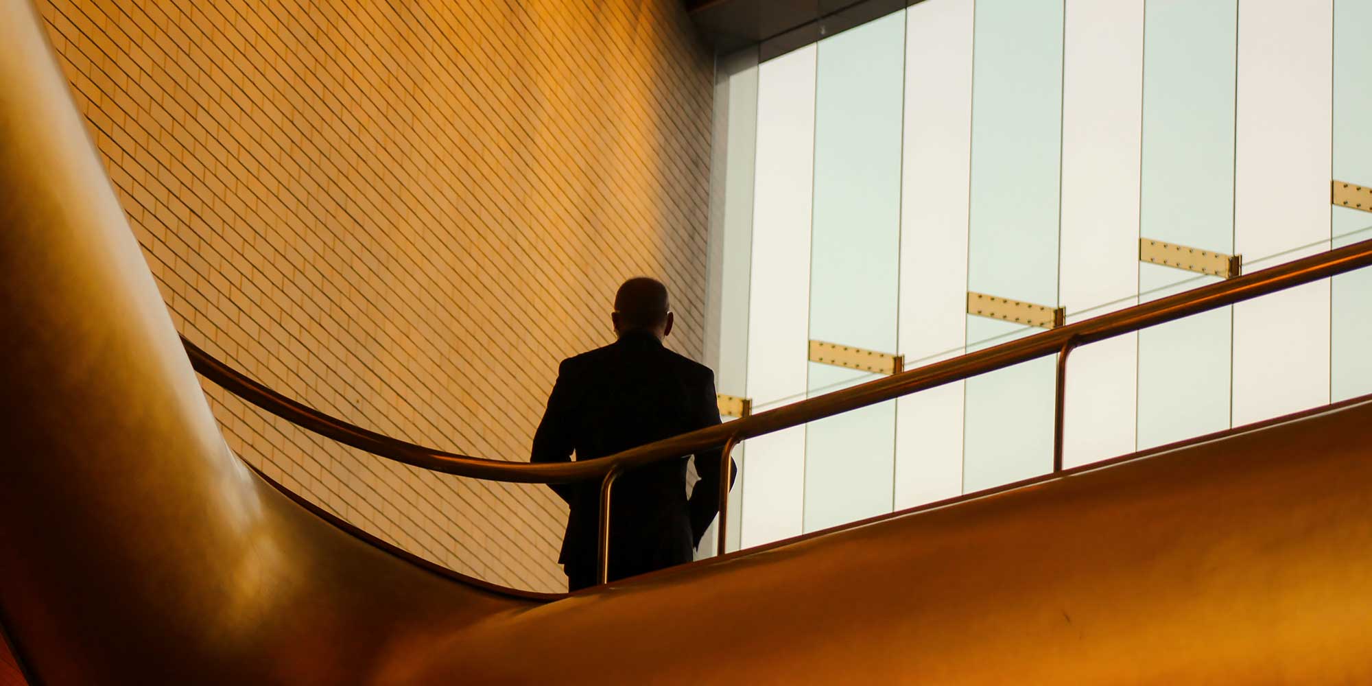 Mężczyzna stoi w cieniu na werandzie biurowca