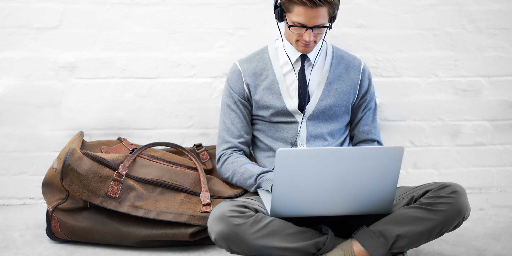 Mężczyzna siedzący na ziemii z laptopen na kolanach