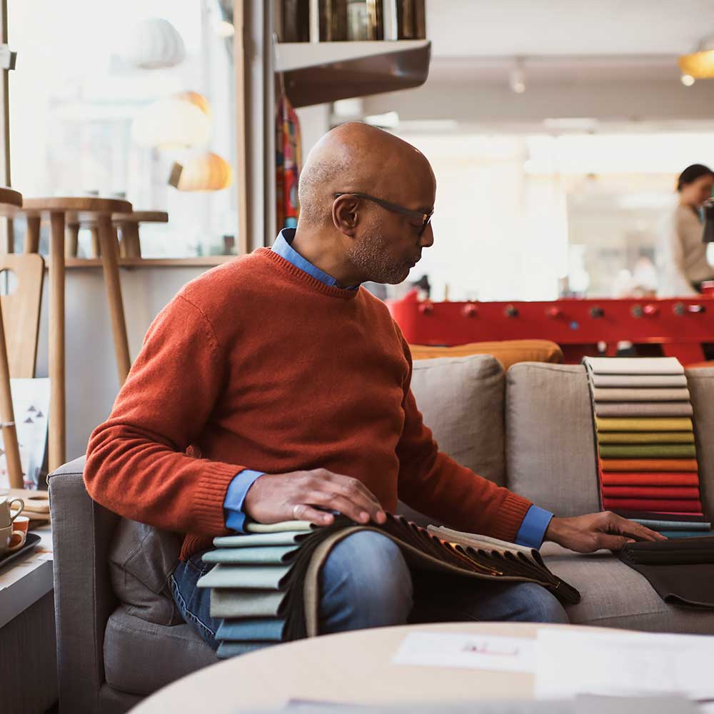 Mężczyzna wybiera kolory z próbnika tkanin