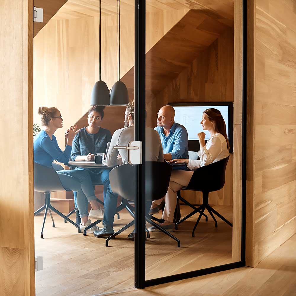 Grupa ludzi w biurze siedzi przed stołem