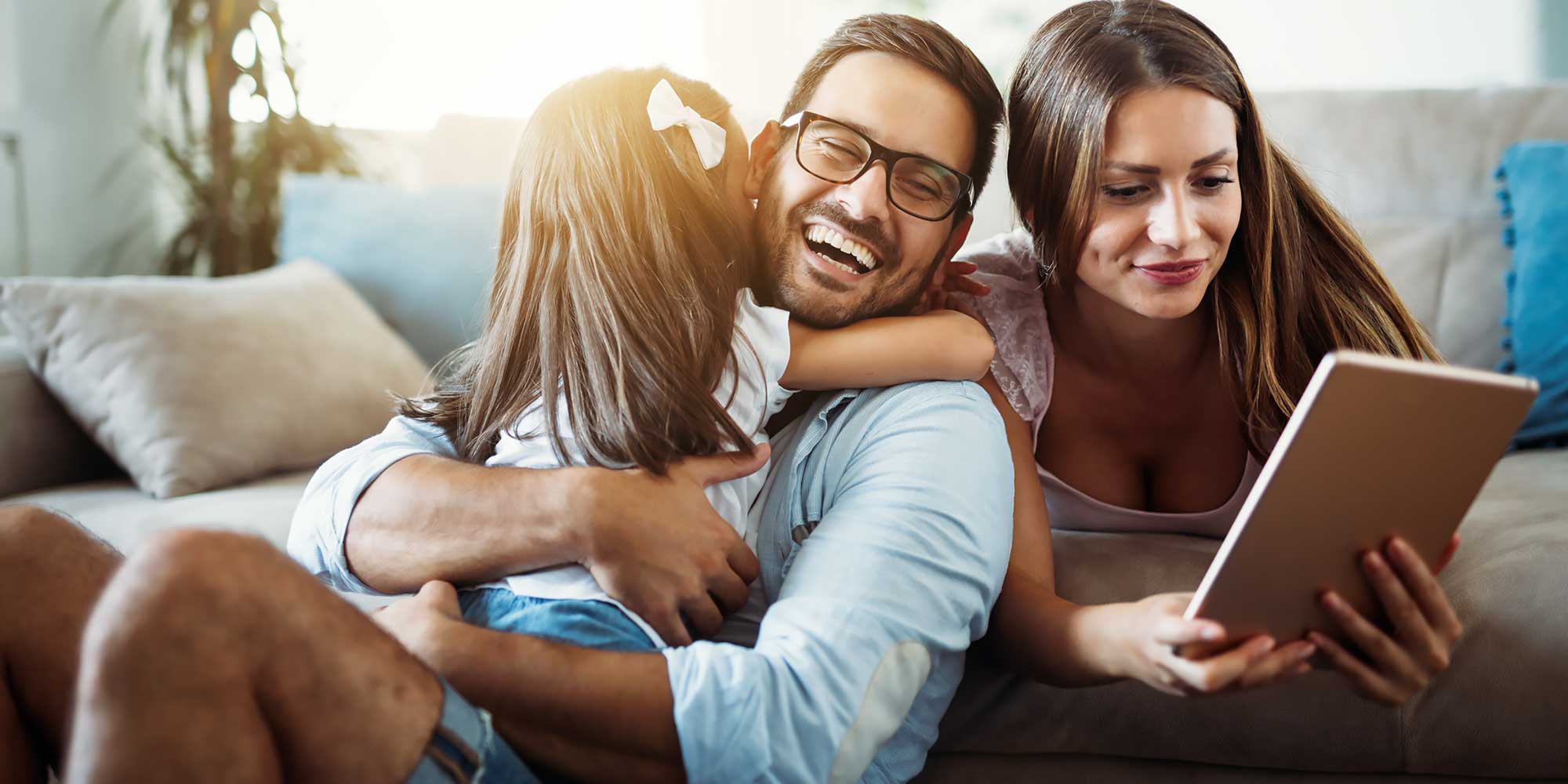 Para kobiety i męzczyzny z dzieckiem smieją się do tabletu 