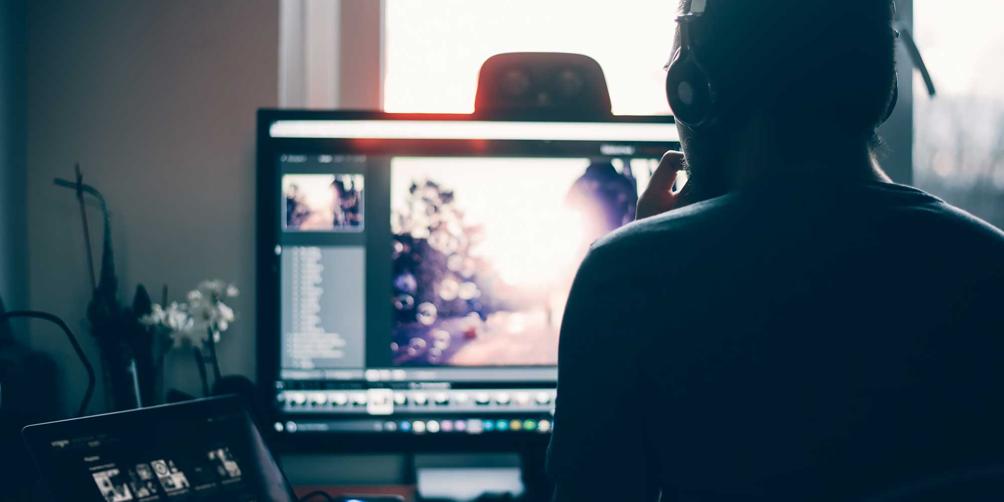 Człowiek odwrócony plecami spoglada na ekran monitora
