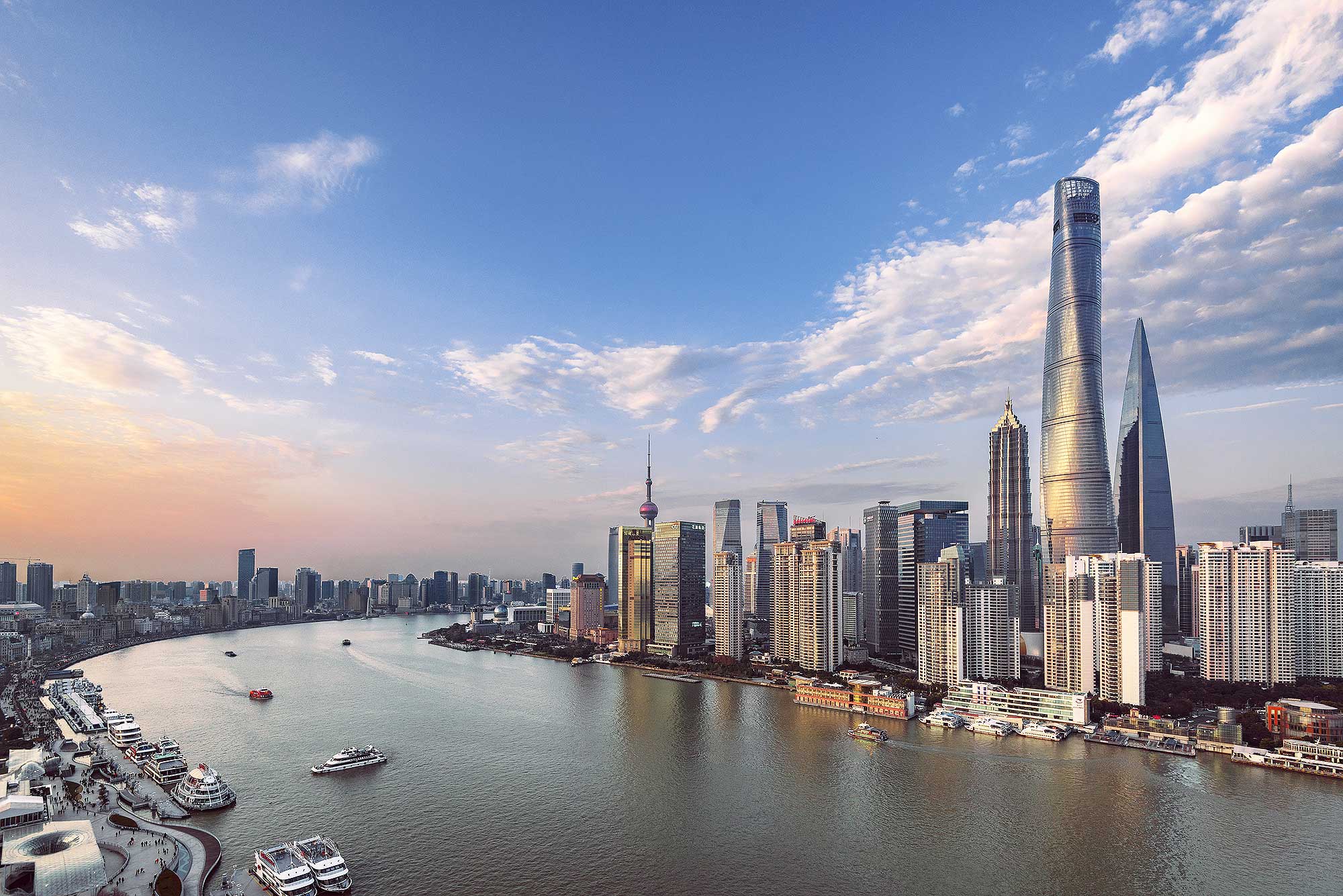 Szanghaj o zachodzie słońca z wysokimi budynkami i wodą