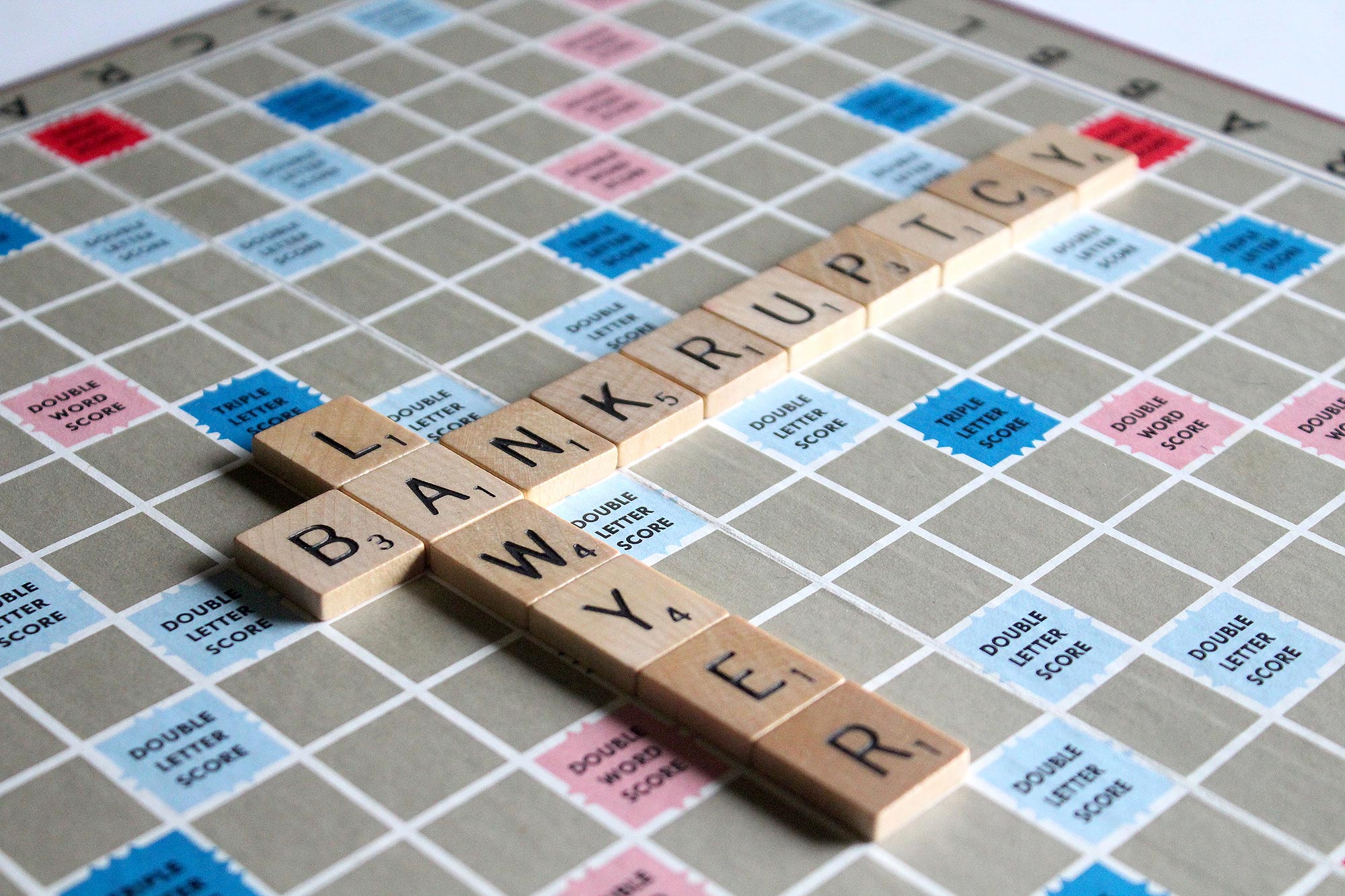 Plansza do gry w Scrabble z pustymi płytkami z napisem "bankructwo"