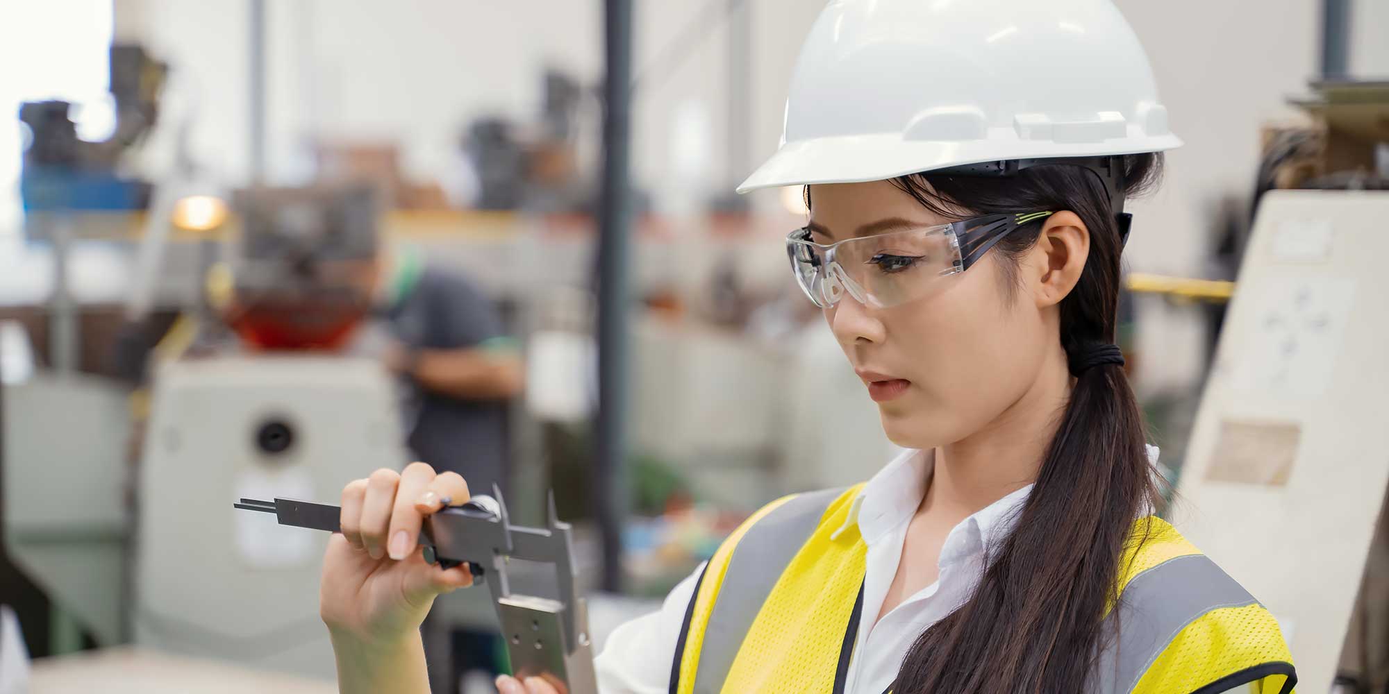 Kobieta Azjatka w białym kasku ochronnym w pracy