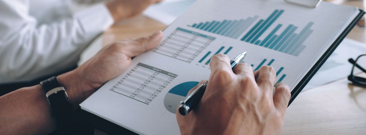 Osoba przegląda dokument z wykresami słupkowymi