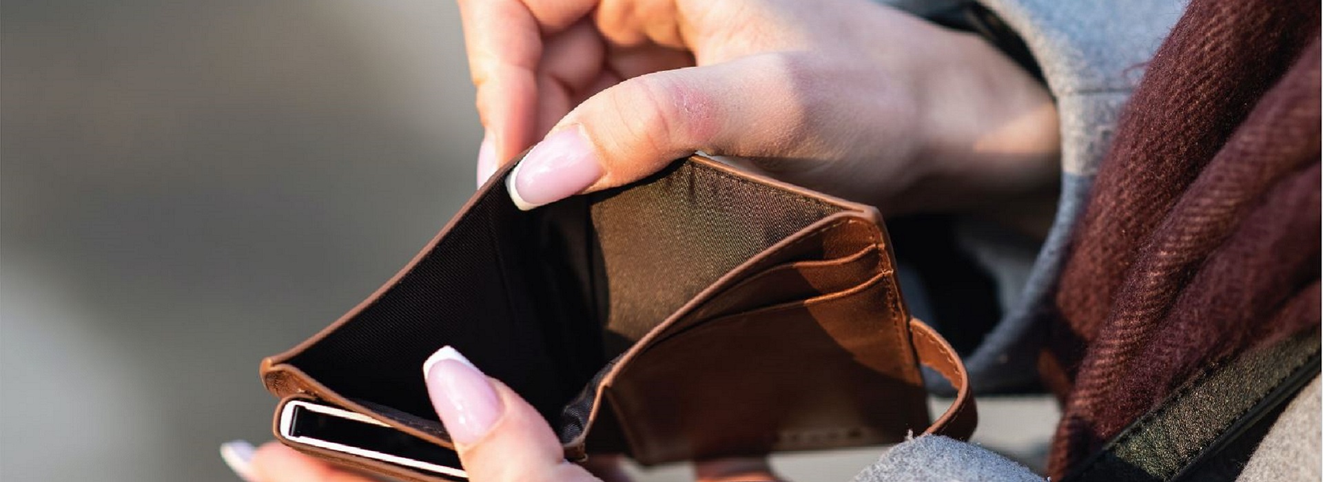 Osoba trzyma brązowy skórzany pusty portfel