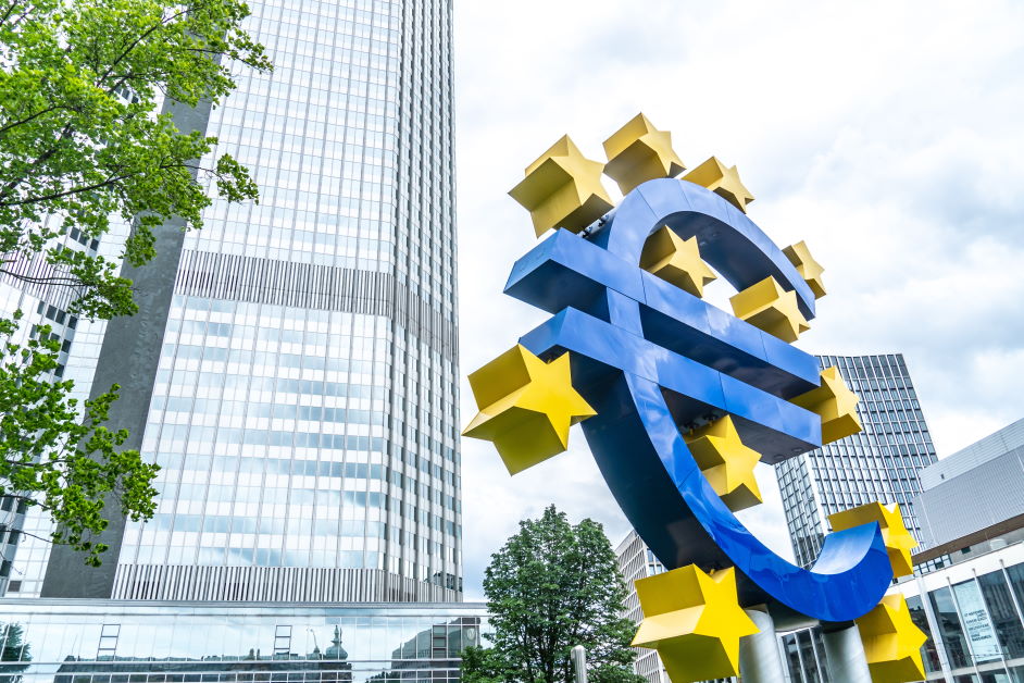 Znak Europejskiego Banku Centralnego z budynkami miejskimi za nim