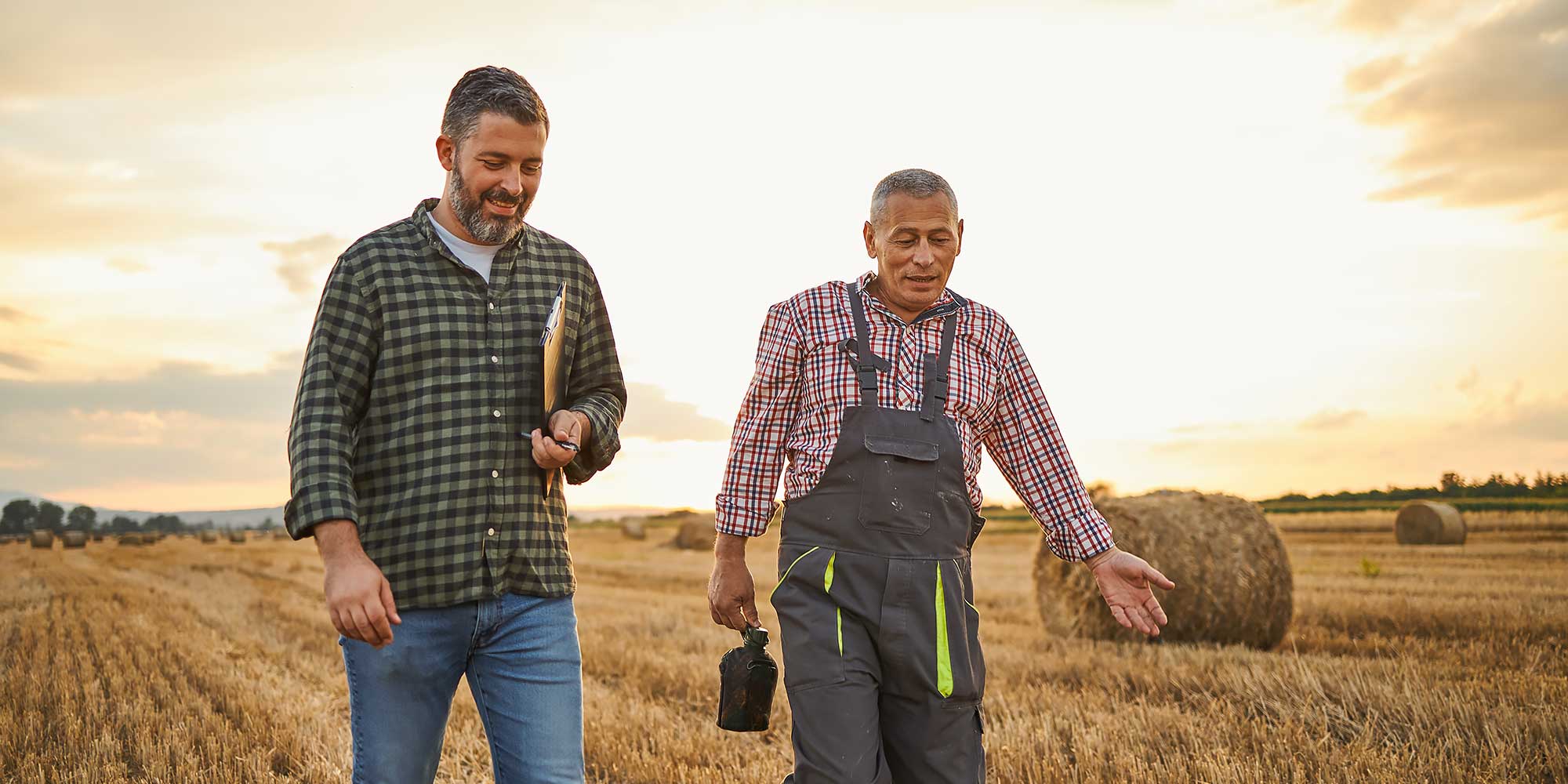 Dwoje mężczyzn spaceruje po polu rolniczym