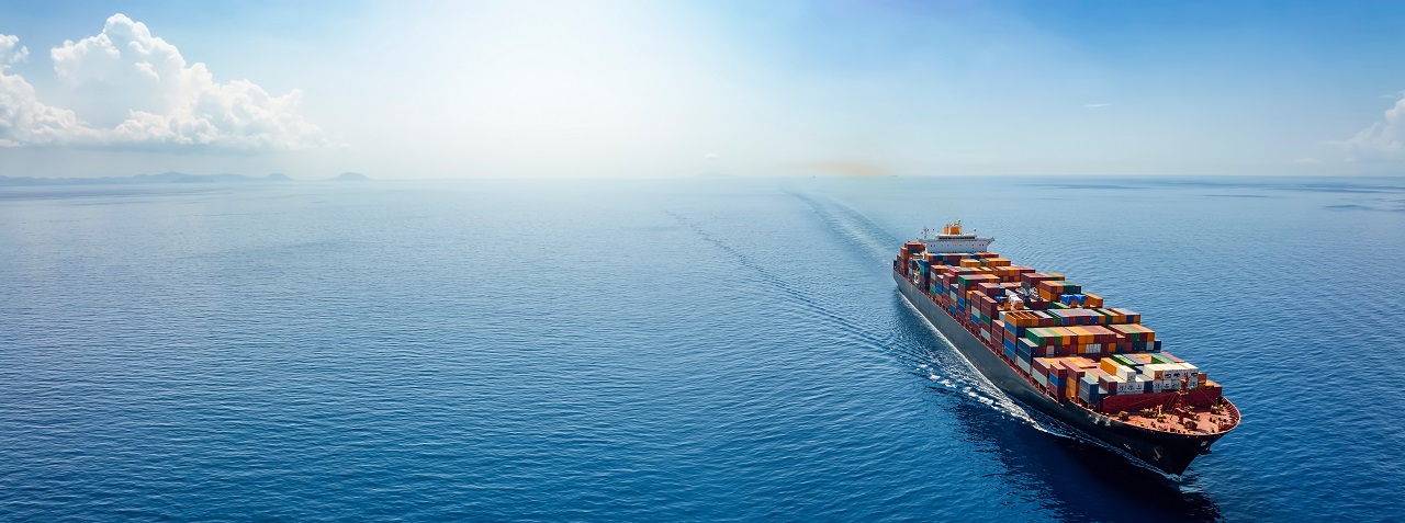 Duży statek na błękitnym morzu z białymi chmurami