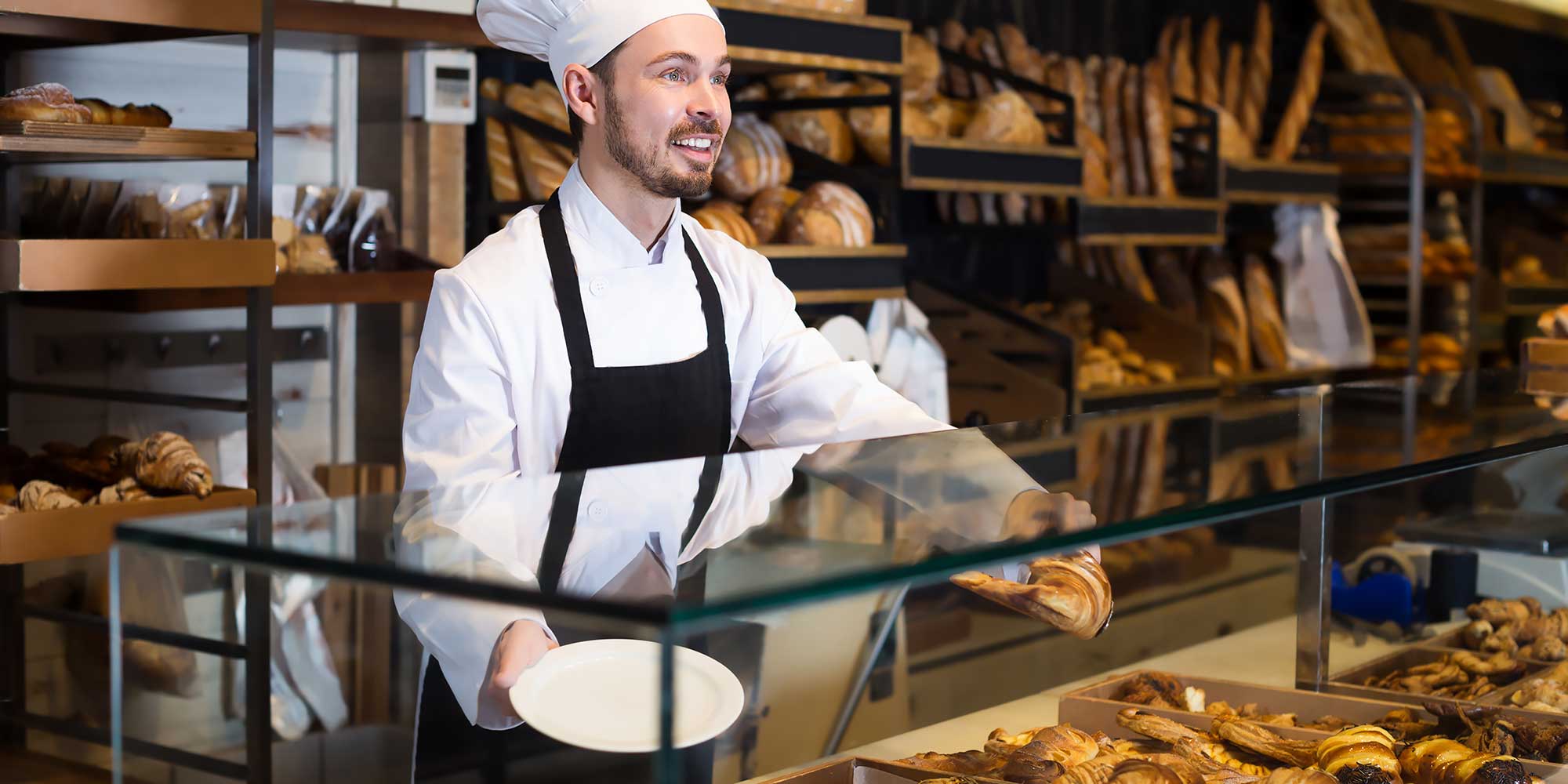 Kucharz w piekarni z takerzem w dłoni