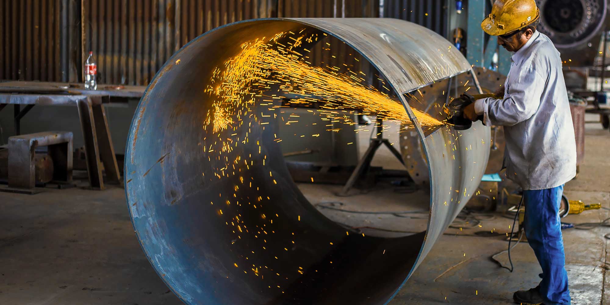 Mężczyzna szlifuje konstrukcje metalową