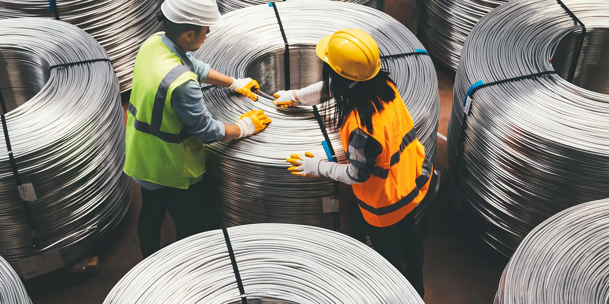 Dwie osoby pośród zwojów metalowych przewodów