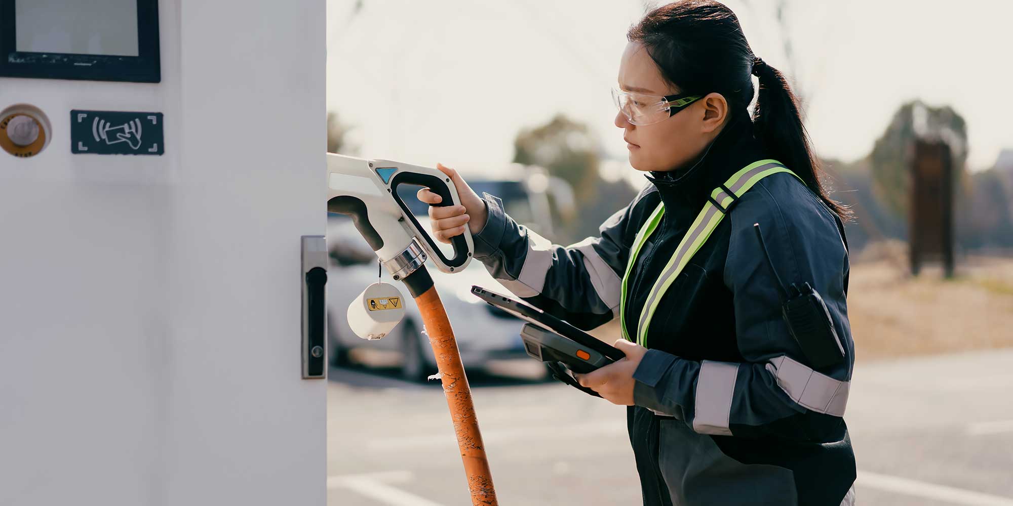 Kobieta na stacji paliw sięga do dystrybutora