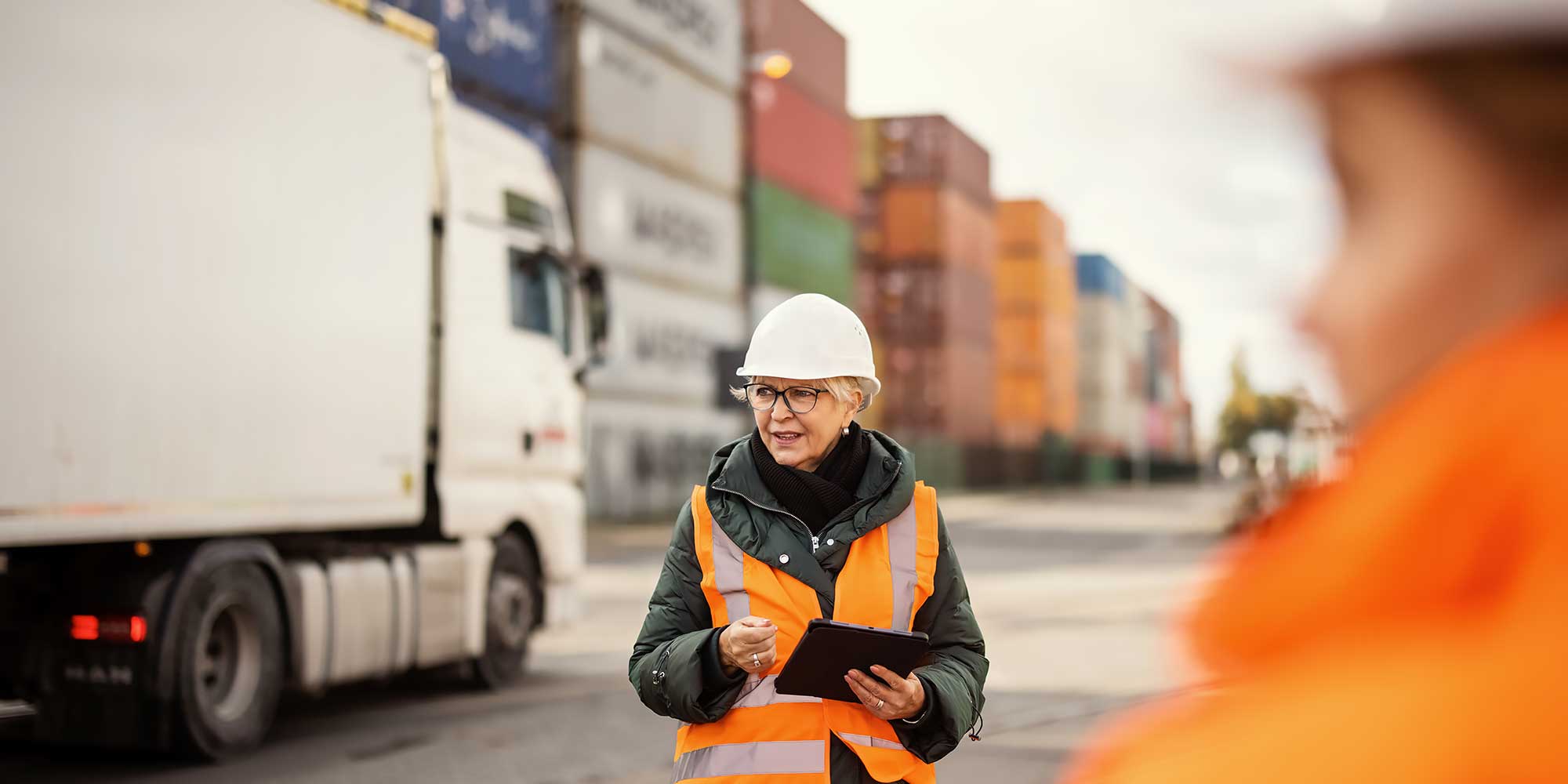 kobieta w kasku ochronnym w porcie przeładunkowym