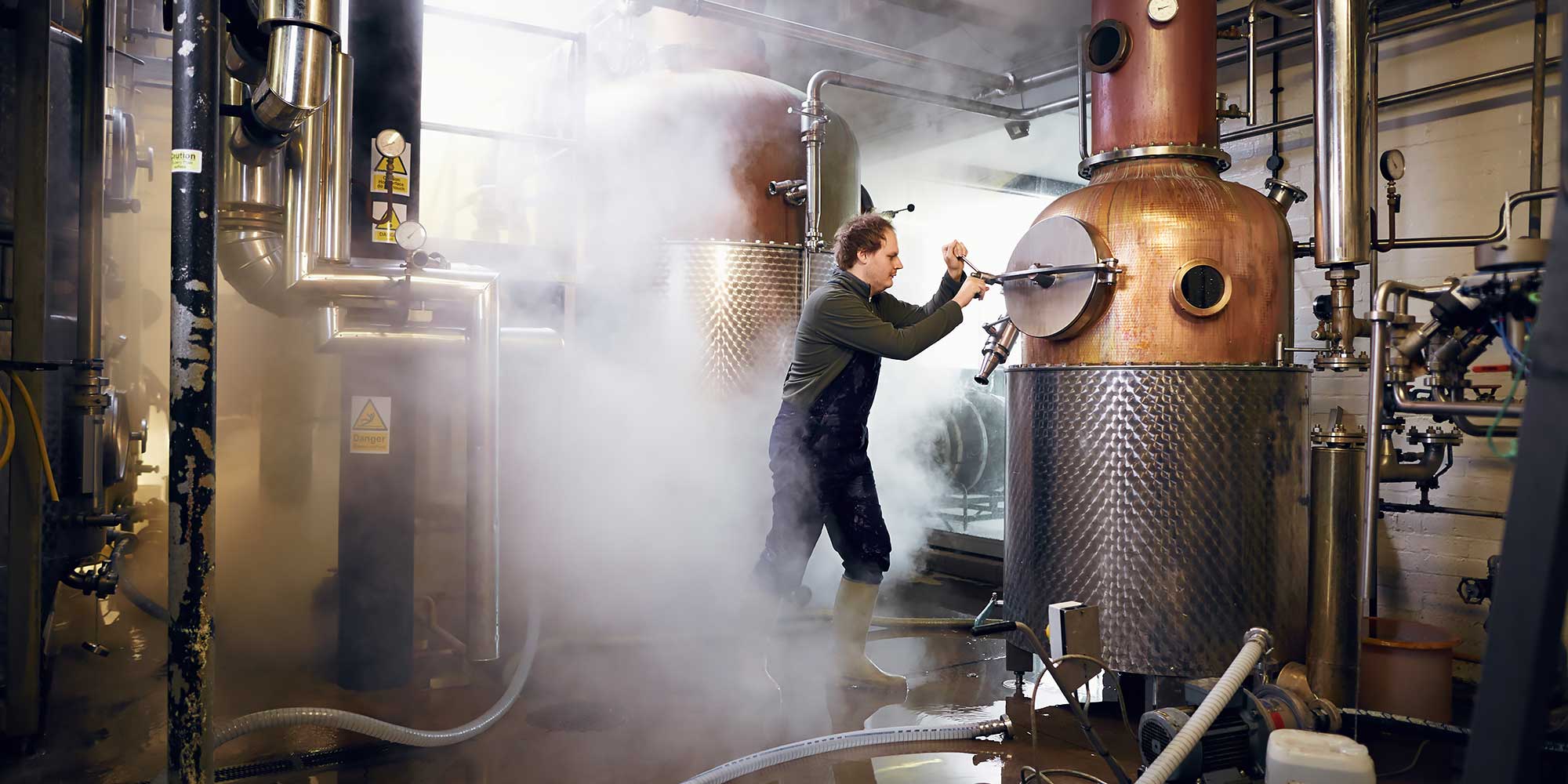 Mężczyzna w obłokach pary operuje pokrętłem 