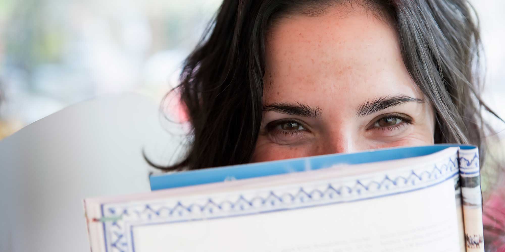 Kobieta wychylająca się zza materiału