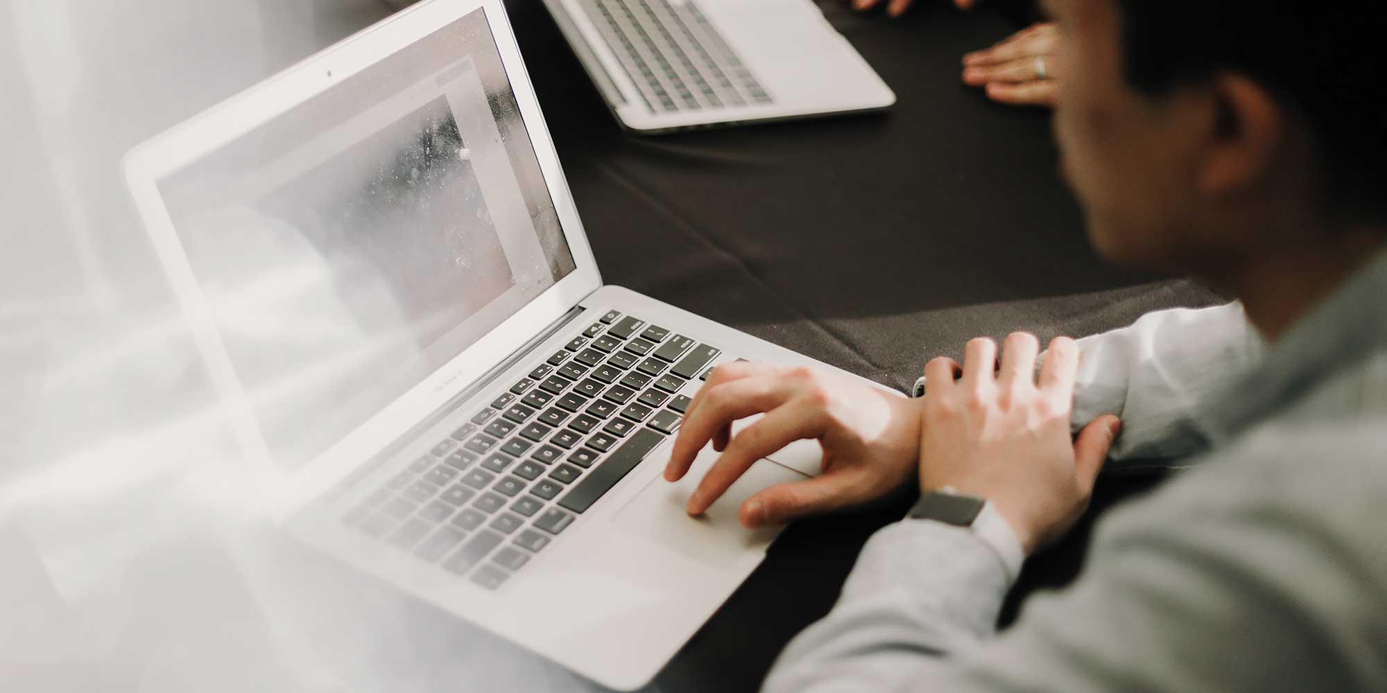 Mężczyzna trzyma ręke na laptopie