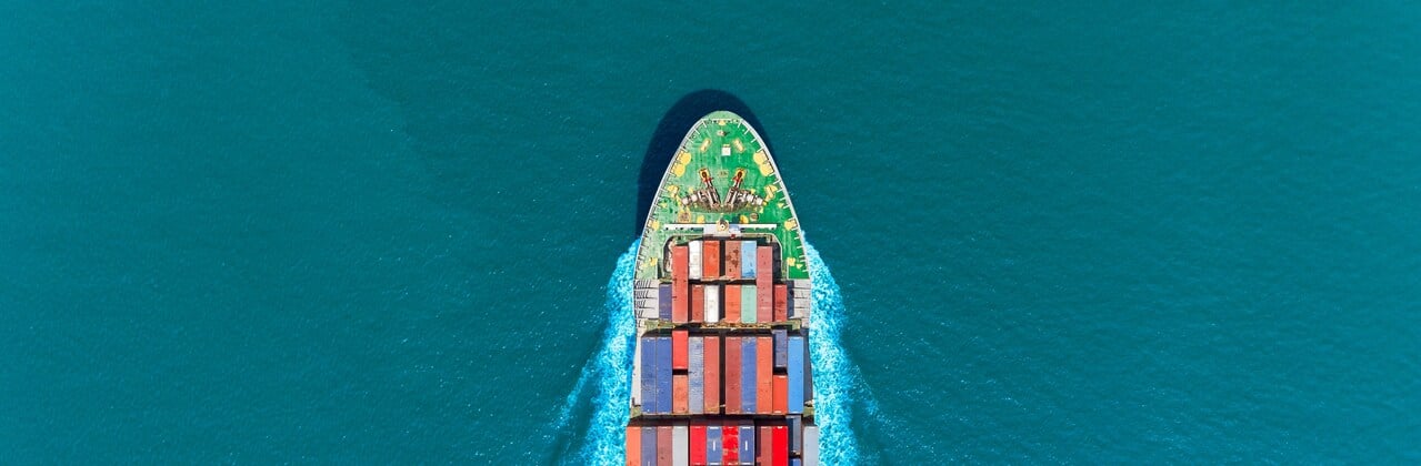 The bow of a cargo ship is breaking through the sea
