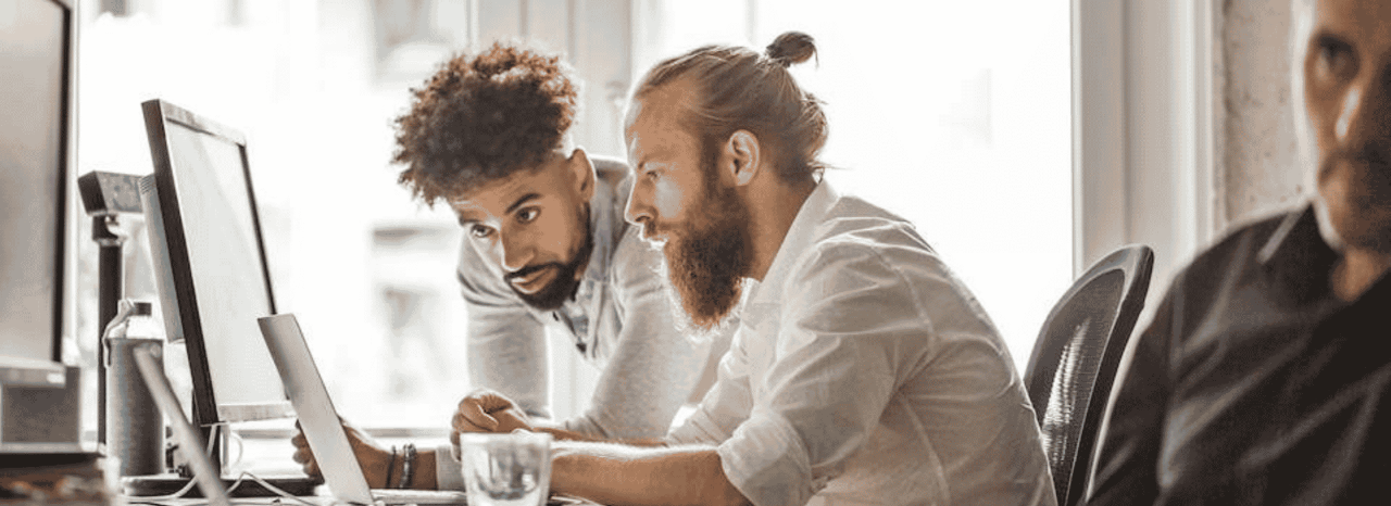 Dois colegas a olhar para um computador