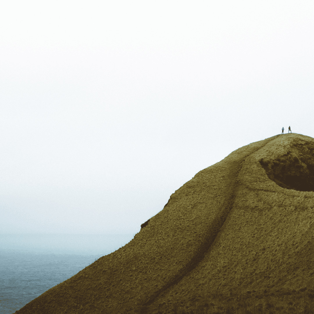 Duas pessoas a viajar pela naturaza no pico de uma montanha